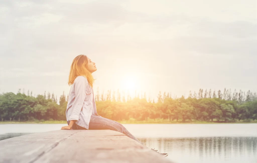 young beautiful hipster woman sitting lake relaxing with